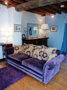 un sofá púrpura en una sala de estar con espejo en The Threshing Barn en Harrogate