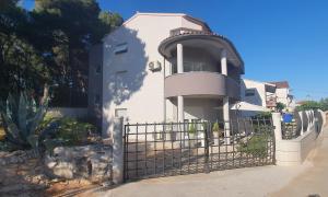 una casa bianca con un cancello davanti di Apartman Tika (2+2)*** a Pola (Pula)