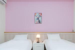2 camas en una habitación con una foto en la pared en 菓香101民宿fruity101 en Shoufeng