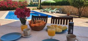 una mesa con una cesta de pan y zumo de naranja en Villa Mar, en Albufeira