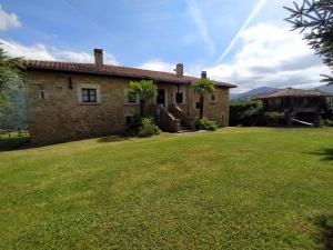 an old stone house with a large yard at La Rectoral in Beloncio