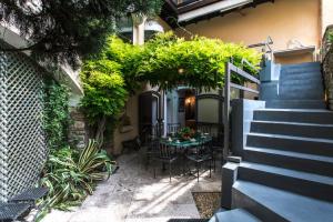 une terrasse avec une table, des chaises et des plantes dans l'établissement Villa Glicine, à Gardone Riviera