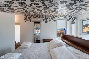 a bedroom with a bed with a floral patterned ceiling at Villa Glicine in Gardone Riviera +22 photos