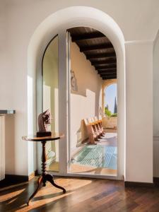 an archway leading into a living room with a table and a mirror at Villa Glicine in Gardone Riviera