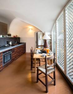 une cuisine avec une table et des chaises et une cuisine avec des fenêtres dans l'établissement Villa Glicine, à Gardone Riviera