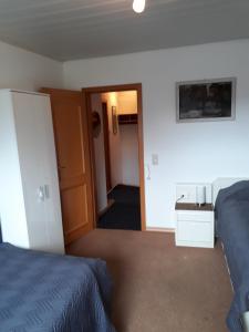 a bedroom with two beds and a door to a hallway at Ferienwohnung Pries in Kiel
