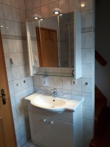 a bathroom with a white sink and a mirror at Ferienwohnung Pries in Kiel