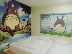 a room with two beds and a large painting on the wall at Sekinchan Boutique Homestay in Sekincan