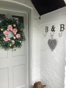 a door with a wreath and a heart on it at Birtles Farm Bed and Breakfast in Knutsford