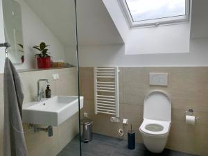 a bathroom with a white toilet and a sink at Exklusives Penthouse im ehemaligen Bunker in Hannover