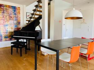 a dining room with a black table and a piano at Exklusives Penthouse im ehemaligen Bunker in Hannover +14 photos