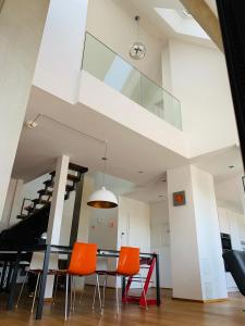 a dining room with a table and orange chairs at Exklusives Penthouse im ehemaligen Bunker in Hannover