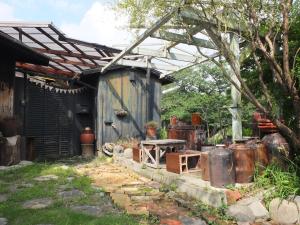 a shed with a table and some rusty containers at YOMOGI GUESTHOUSE in Tokoname