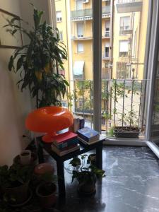 a room with a chair and books and a window at A due passi dal Lumière in Bologna