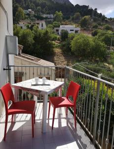 a table and chairs on a balcony with a view at Casetta "Le Due Palme" in Castellammare del Golfo
