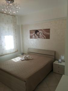 una camera con un letto con una foto sul muro di Casetta "Le Due Palme" a Castellammare del Golfo