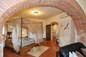 1 dormitorio con cama con dosel en una habitación en Agriturismo Il Bottaccino, en Monsummano