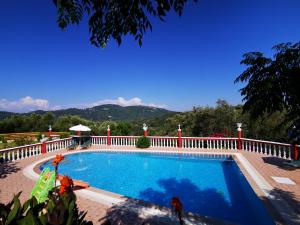 a swimming pool with a fence and mountains in the background at Villa PANGALIS Romantica in Kato Pavliana