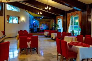 a dining room with tables and red chairs at Hotel Belvedere in Predeal