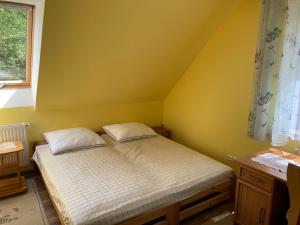 sypialnia z łóżkiem w żółtym pokoju w obiekcie Agroturystyka Sokoliki w mieście Karpniki