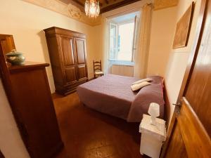 um pequeno quarto com uma cama e uma janela em Casa Teatro em Cortona