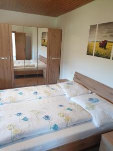 two beds in a bedroom with a mirror at Apartment Gabraunerhof in Pernegg an der Mur +17 photos