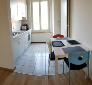 HSH Weber - 2 Bedroom Suite Apartment with Office, Salon and Kitchen in Bern by HSH Hotel Serviced Home في برن: مطبخ صغير مع طاولة وطاولة وكراسي