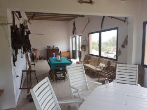 Zimmer mit weißen Stühlen, einem Tisch und einem Fenster in der Unterkunft Casa Sol y Vida Tabernas in Tabernas