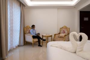 a woman sitting in a chair in a hotel room at Alhattali Hotel in Muscat