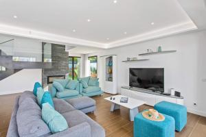 a living room with blue furniture and a fireplace at Villa Ohana in Albufeira