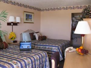 una habitación de hotel con 2 camas y un ordenador portátil en una mesa en Seminole Inn en Seminole