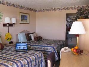 a hotel room with two beds and a laptop on a desk at Seminole Inn in Seminole