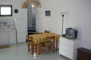 appartamentino in villa antica في مارينا سيرا: مطبخ مع طاولة مع كراسي وميكروويف
