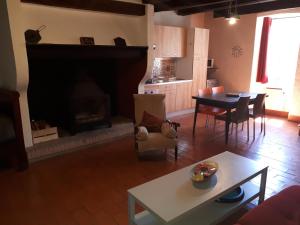 - un salon avec une cheminée et une table dans l'établissement La cardabelle, à Saint-Maurice-Navacelles