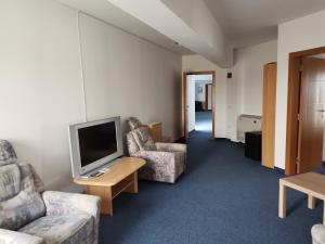 a living room with two chairs and a television at Plaža in Varvarin