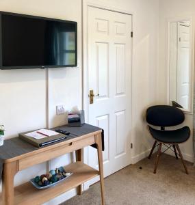 a room with a table and a chair and a television at Kilmuir Park in Dunvegan