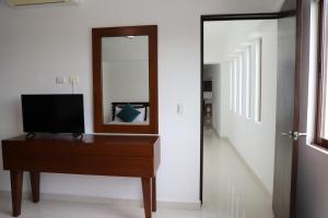 a room with a desk with a television and a mirror at Porto Real in Ciudad del Carmen