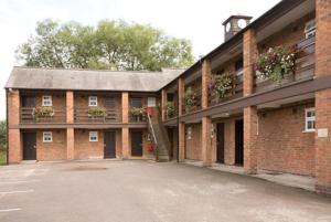 a brick building with flower boxes on the windows at Mill On The Soar by Greene King Inns in Broughton Astley