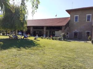grupa ludzi siedzących na podwórku przed budynkiem w obiekcie B&B Cascina dell'eco w mieście Busca +5 zdjęć