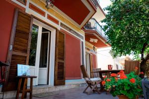 B&B De Angelis في جينوسا مارينا: شرفة منزل مع طاولة وزهور