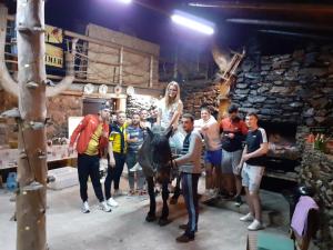 Eine Frau auf einem Pferd mit einer Gruppe von Menschen in der Unterkunft Cabana Virful Muntelui in Câmpeni