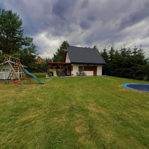 a large yard with a house and a playground at Letnia Ostoja Wieprz in Wieprz