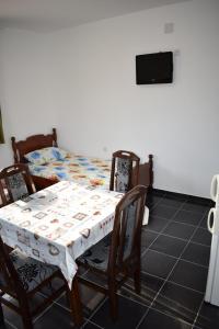 a dining room table with chairs and a bed at Srebrna Nit in Veliko Gradište