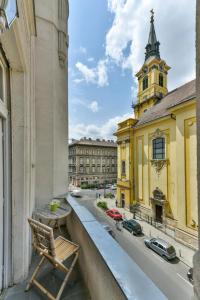 una silla sentada en un balcón con vistas a la ciudad en King of Church Budapest, en Budapest