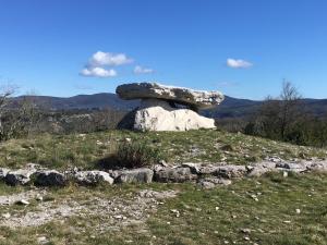 a rockolith sitting on top of a grassy hill at La cardabelle in Saint-Maurice-Navacelles