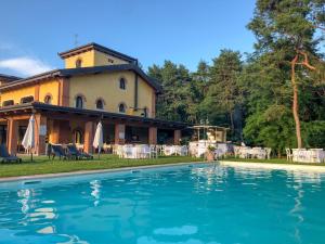 a house with a swimming pool in front of it at Agriturismo Il Boschetto in Ornago