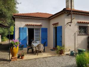 une maison avec des portes bleues, une table et des chaises dans l'établissement LiseManu, à Juan-les-Pins