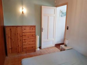 a bedroom with a bed and a wooden dresser and a door at LiseManu in Juan-les-Pins