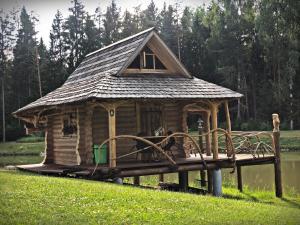 a log cabin on a dock with a bridge at Mežvidi in Velēna