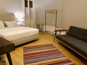 a bedroom with a bed and a couch and a rug at Porto Republica Downtown in Porto